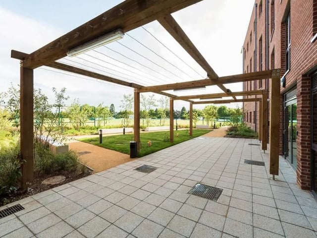Paved walkway under wooden pergola building exterior at Cricket Field Court in Exeter Student Accommodation