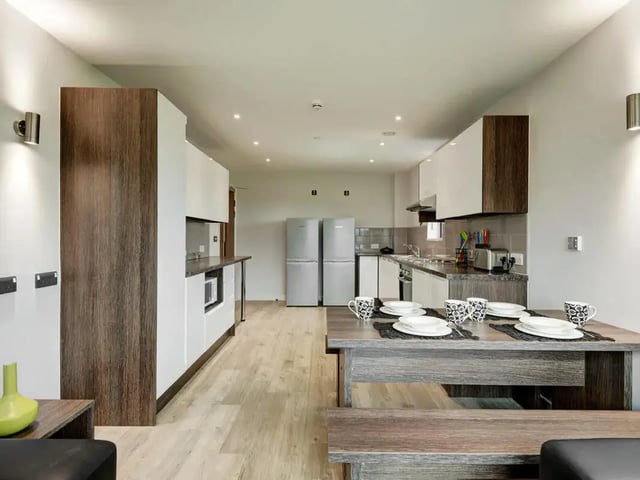 Dining table with place settings and kitchen living room at Cricket Field Court in Exeter Student Accommodation