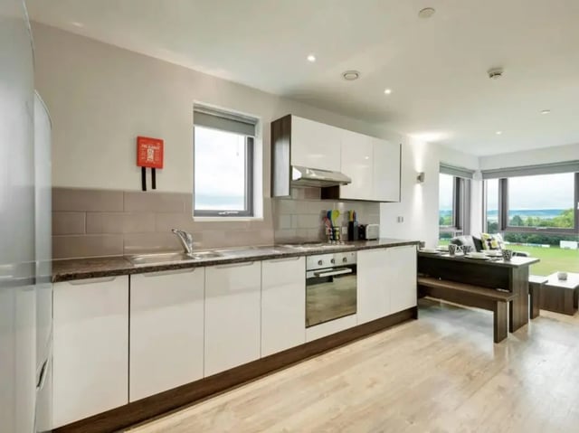 Modern kitchen with appliances dining bench living area at Cricket Field Court in Exeter Student Accommodation