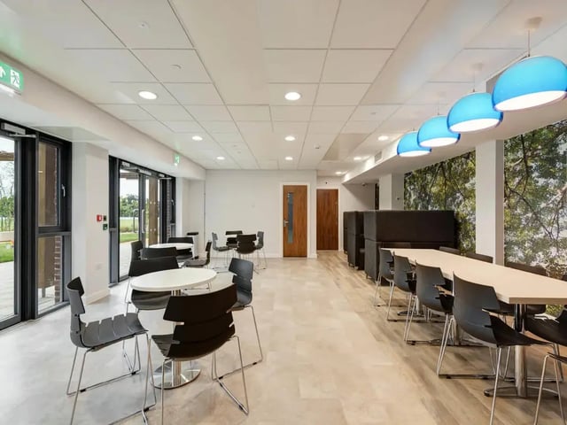 Tables chairs and blue pendant lights communal area at Cricket Field Court in Exeter Student Accommodation
