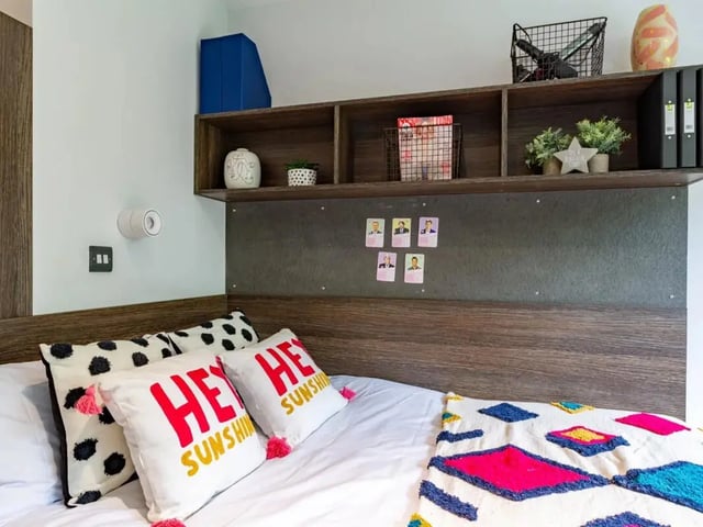 Bed with decorative pillows and shelf Bedroom at Cricket Field Court in Exeter Student Accommodation