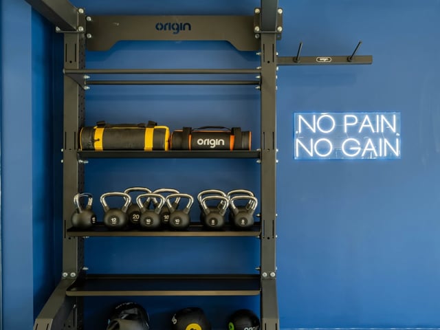 Kettlebells weight bags neon sign gym area at The Brook in Bath Student Accommodation
