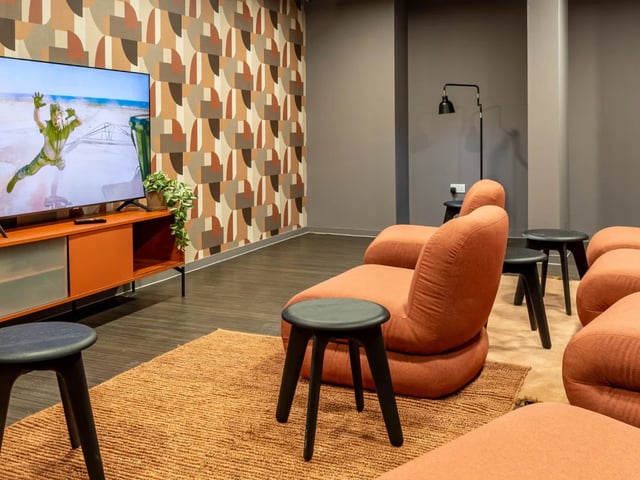 Television orange cabinet patterned wall chairs living room at The Brook in Bath Student Accommodation