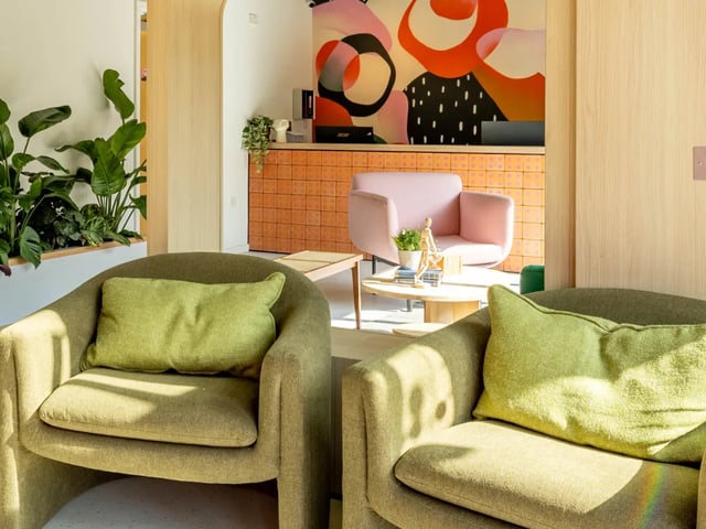 Two green armchairs and reception desk living room at The Brook in Bath Student Accommodation