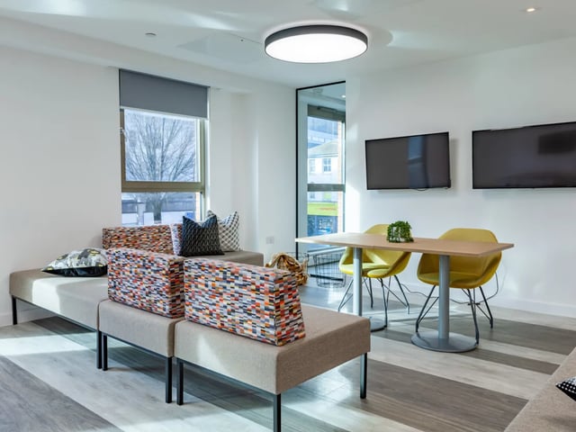 Sofa table chairs televisions living room at Pavilion Point in Brighton Student Accommodation