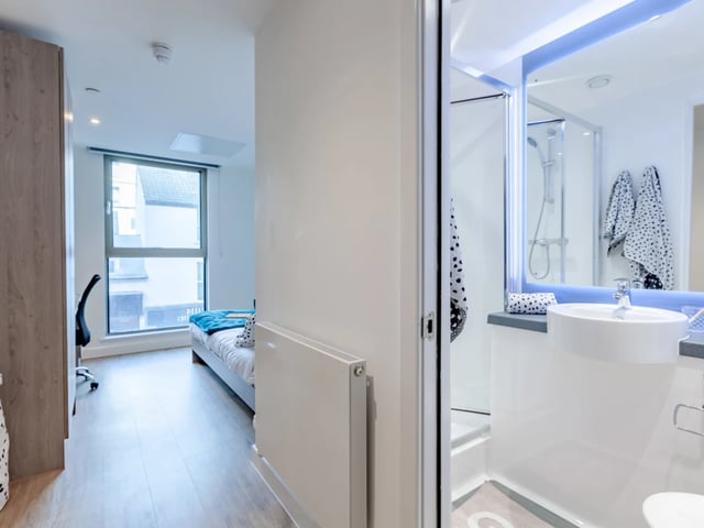 Bed desk radiator and modern bathroom interior at Pavilion Point in Brighton Student Accommodation