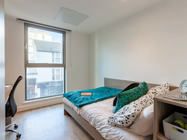 Bed desk chair and pillows bedroom at Pavilion Point in Brighton Student Accommodation