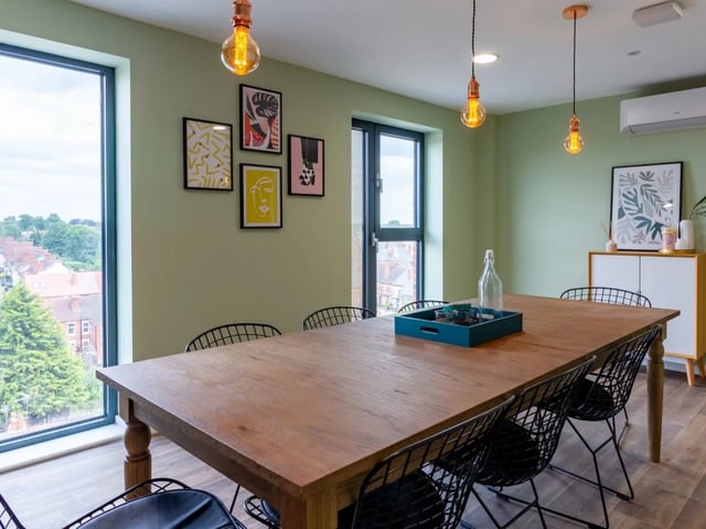 Wooden dining table black chairs framed art dining area at Gulson Gardens in Coventry Student Accommodation