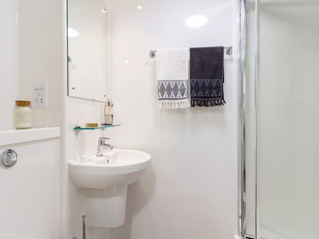 Sink mirror towels and shower cabin bathroom at Dun Holm House in Glasgow Student Accommodation