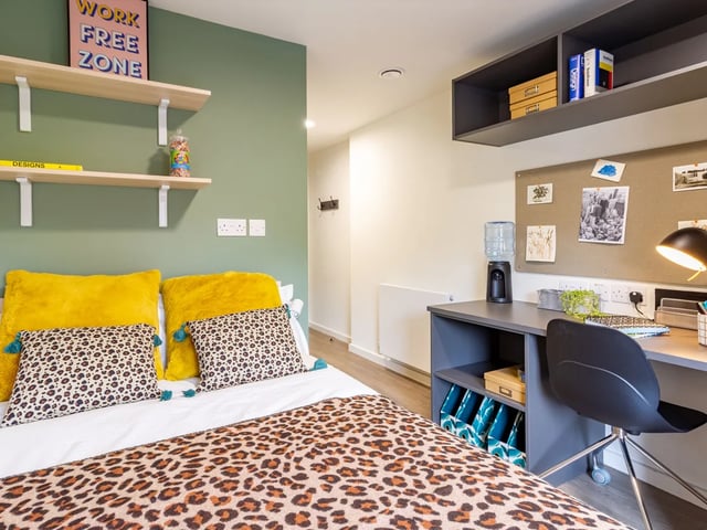 Leopard print bed yellow cushions desk study area at Dun Holm House in Glasgow Student Accommodation