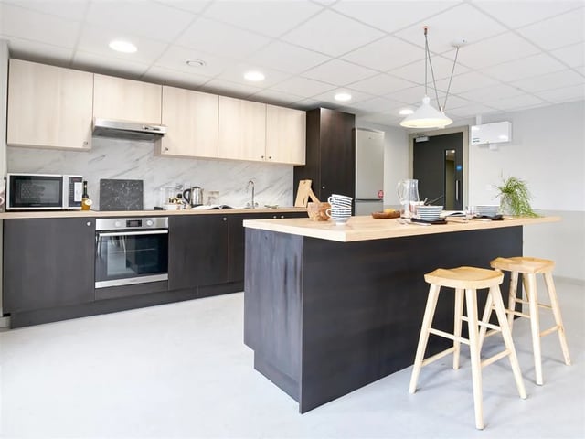 Modern kitchen island with stools and appliances kitchen at Dun Holm House in Glasgow Student Accommodation