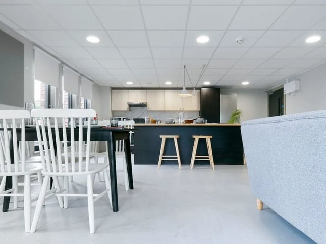 Dining table chairs kitchen island stools living room area at Dun Holm House in Glasgow Student Accommodation