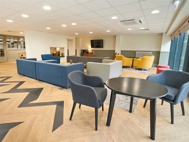 Sofa chairs table and herringbone floor communal area at Dun Holm House in Glasgow Student Accommodation