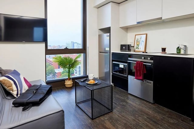TV sofa coffee table kitchen and oven living room at Scape Queensberry in Melbourne Student Accommodation