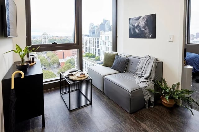 Sofa coffee table plant and umbrella living room at Scape Queensberry in Melbourne Student Accommodation