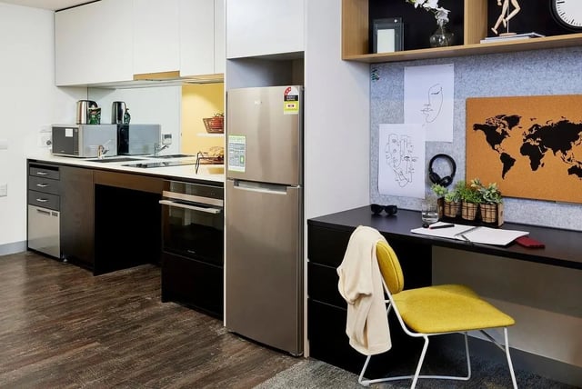 Modern kitchen counter microwave fridge oven desk living room at Scape Queensberry in Melbourne Student Accommodation