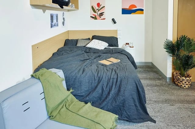 Bed sofa bedside table plant bedroom at Scape Queensberry in Melbourne Student Accommodation