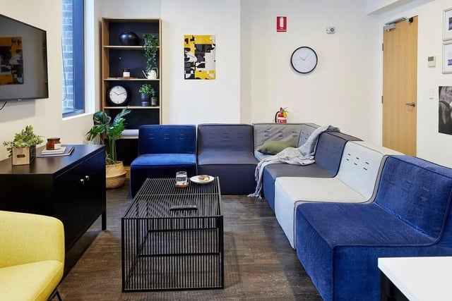 Modular sofa black cabinet shelving clock living room at Scape Queensberry in Melbourne Student Accommodation