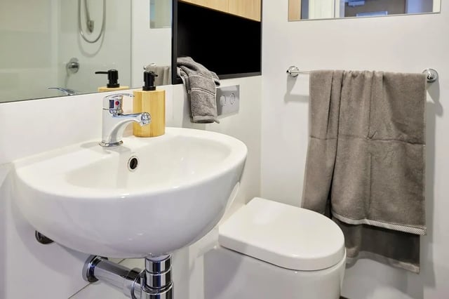 Sink toilet soap dispenser towel bathroom at Scape Queensberry in Melbourne Student Accommodation