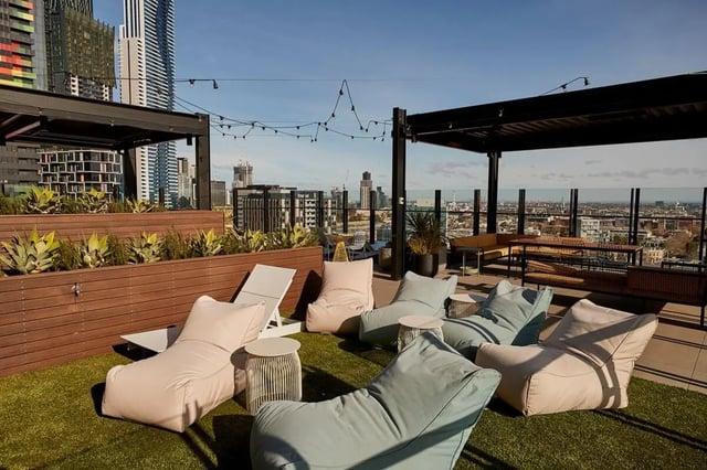 Beanbags lounge chairs string lights cityscape communal area at Scape Queensberry in Melbourne Student Accommodation