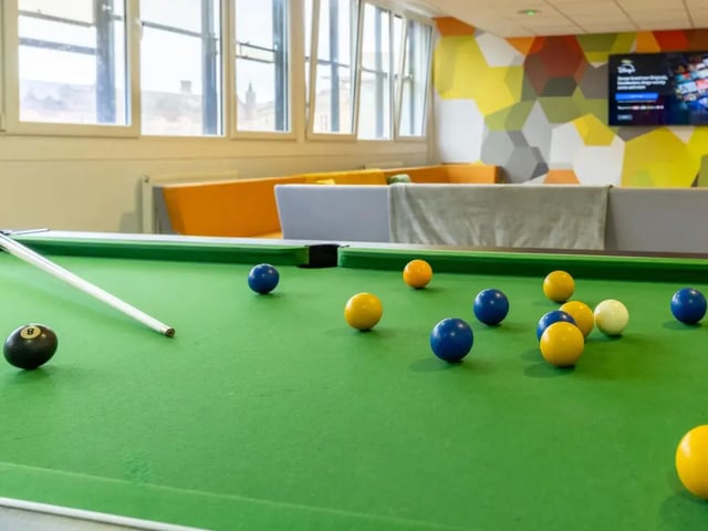 Pool table with balls and cue playing area at MyPad Paisley in Paisley Student Accommodation