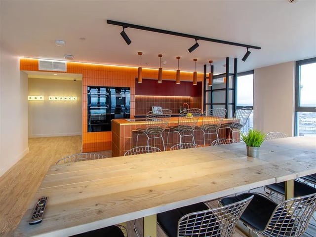 Dining table bar chairs kitchen and sky lounge living area at Calico in Liverpool Student Accommodation