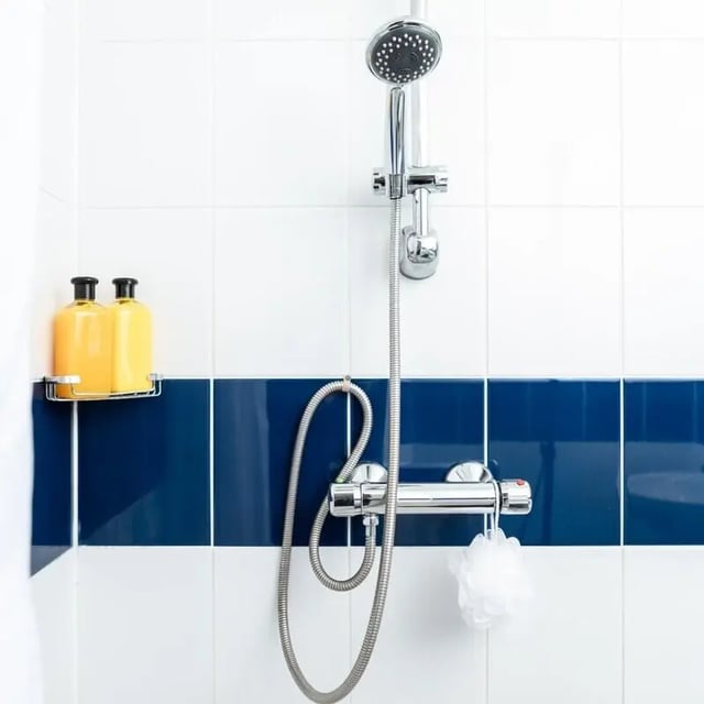 Shower head bottles and loofah bathroom at Okeford House in Bournemouth Student Accommodation