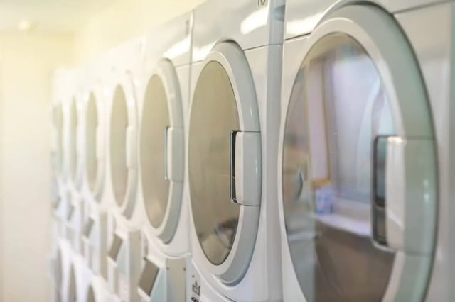 Row of white washing machines laundry area at Okeford House in Bournemouth Student Accommodation