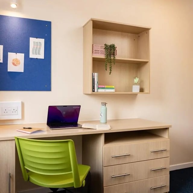 Desk with laptop and green chair study area at Okeford House in Bournemouth Student Accommodation