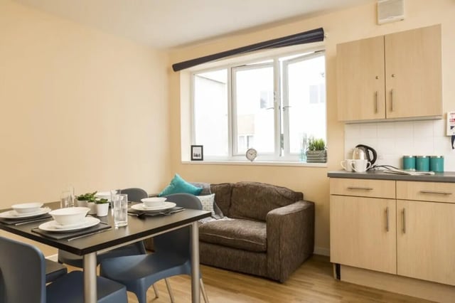 Dining table sofa kitchen counter and cabinets living room at Okeford House in Bournemouth Student Accommodation