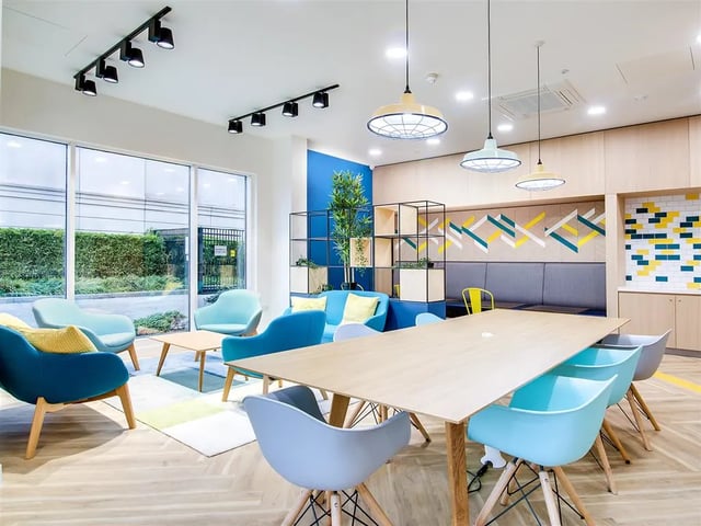 Modern lounge with colorful chairs and large table communal area at New Orient House in London Student Accommodation