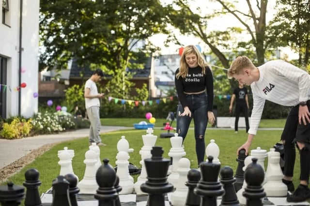 Giant chess pieces on lawn students playing exterior at Prince Consort Village in London Student Accommodation