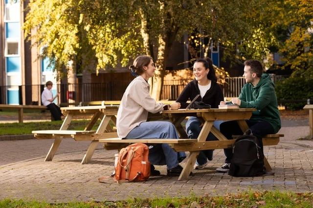 Students talking at picnic table exterior. at Cedar House in Liverpool Student Accommodation