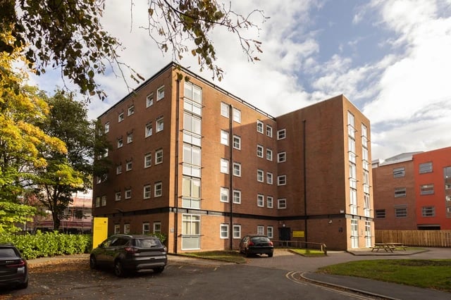 Brick building with parked cars and trees exterior at Cedar House in Liverpool Student Accommodation