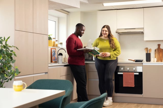 Couple in kitchen reading cooking book kitchen at Cedar House in Liverpool Student Accommodation