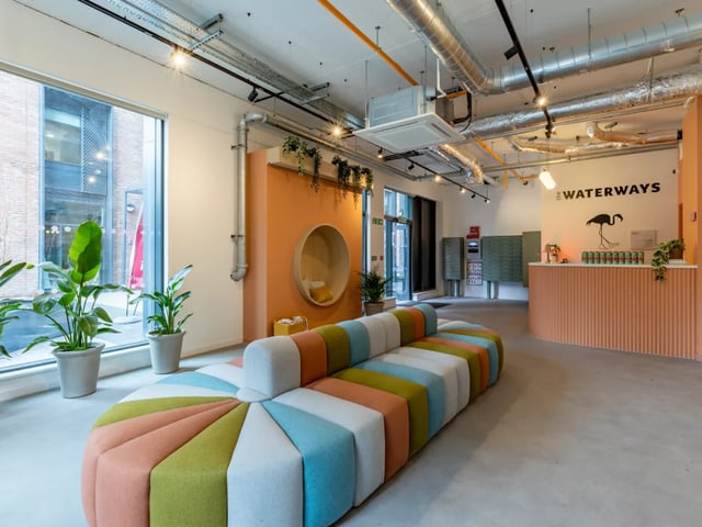 Colorful sofa plants reception desk communal area at The Waterways Nottingham in Nottingham Student Accommodation