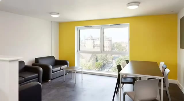 Black couches and dining table with chairs living room at Townhall Camberwell in London Student Accommodation