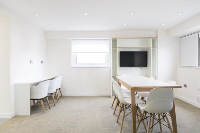 White chairs and table with television study area at John Lester and Eddie Colman Courts in Salford Student Accommodation