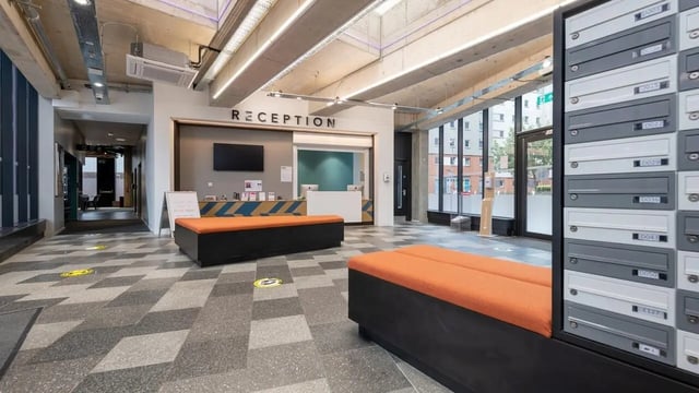 Reception mailboxes orange benches modern lobby at Collegiate Bagot Street in Birmingham Student Accommodation