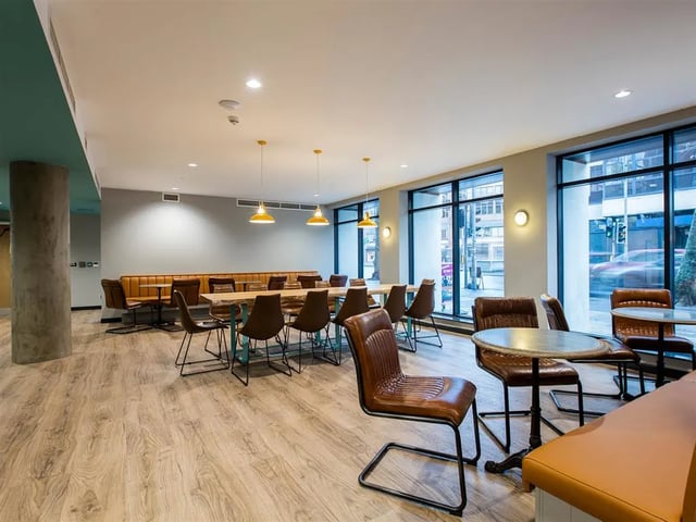 Large communal dining area with tables and chairs Living room at Botanic Studios in Belfast Student Accommodation