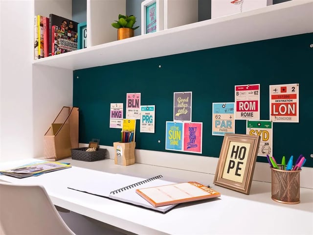 Desk with papers pens and framed HOPE art study area at Botanic Studios in Belfast Student Accommodation