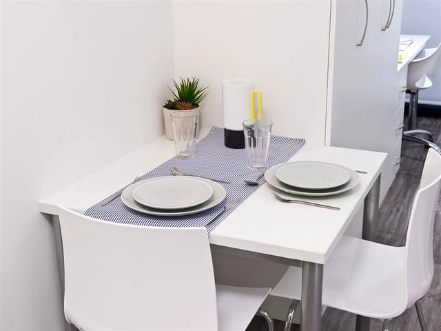 Table with plates glasses plant kitchen counter at Botanic Studios in Belfast Student Accommodation
