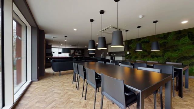 Long black tables chairs large windows communal area living room at One London Road in Newcastle Under Lyme Student Accommodation
