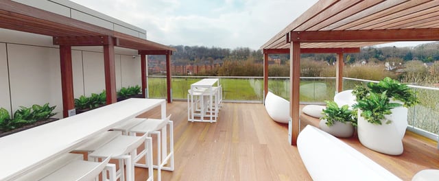 Outdoor deck with white tables chairs and plants at One London Road in Newcastle Under Lyme Student Accommodation