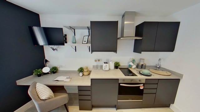 TV desk chair kitchen appliances and cabinets kitchen at Dojo House Nottingham in Nottingham Student Accommodation