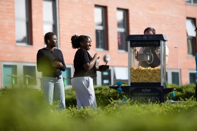 People at popcorn machine exterior event at Peel Park Quarter in Salford Student Accommodation