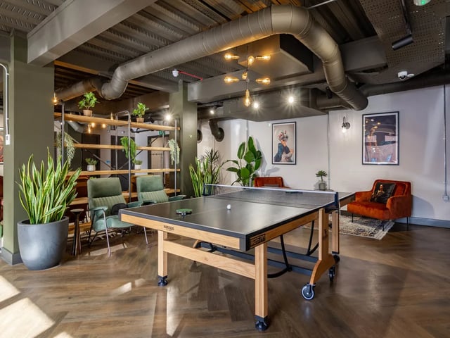 Ping pong table chairs and plants living room at Truro Sheffield in Sheffield Student Accommodation