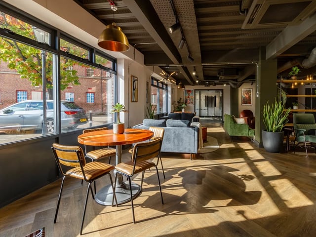 Wooden table chairs sofas and plants communal area at Truro Sheffield in Sheffield Student Accommodation