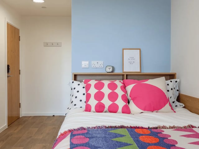 Bed with colorful pillows and blanket bedroom at Ty Nant in Swansea Student Accommodation