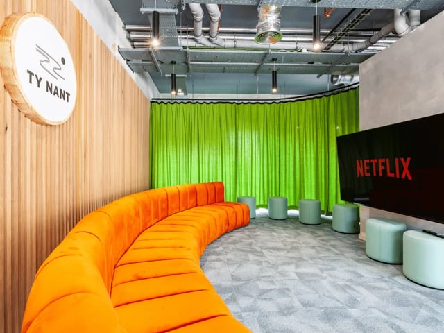Orange sofa Netflix screen mint stools common area at Ty Nant in Swansea Student Accommodation